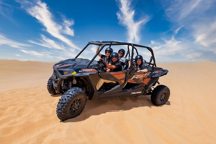 Experience the excitement of dune bashing camel rides and sandboarding against the stunning backdrop of Dubai's golden sands all while enjoying convenient hotel pickups and friendly guides.